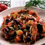 Ricetta carciofi con cipolla, pomodoro, capperi, olive e pinoli: contorno da 175 calorie